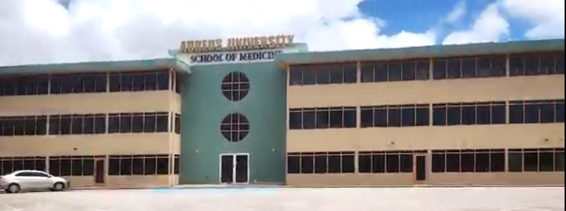 Aureus University campus exterior in Oranjestad, Aruba with palm trees